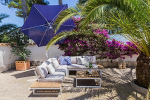a patio with a couch and a purple umbrella at Villa Casa Vincella in Balcon del Mar