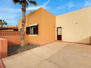 una casa blanca y naranja con una palmera en Casa Aloe, en Corralejo
