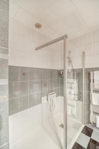 a bathroom with a shower and a tub with a glass door at Contact Hôtel Limoges - HOTEL DES DEUX MOULINS - Ex HOTEL BONI in Limoges
