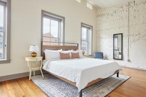 een witte slaapkamer met een groot bed en een tafel bij Sonder Ellis Square in Savannah