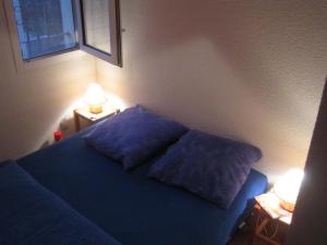 a bedroom with a blue bed with two pillows at Vias Plage - Maison de vacances in Vias