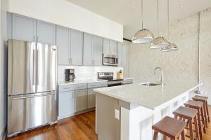 uma cozinha com armários brancos e um frigorífico de aço inoxidável em Sonder Ellis Square em Savannah