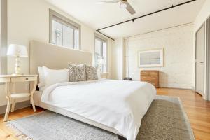 um quarto branco com uma cama grande e uma mesa em Sonder Ellis Square em Savannah