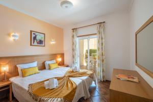 a bedroom with a bed and a desk and a window at Jardins Vale de Parra in Albufeira +62 photos