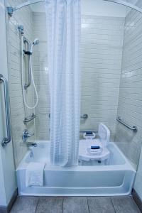 a bathroom with a shower and a tub with a toilet at Candlewood Suites Fargo-North Dakota State University, an IHG Hotel in Fargo