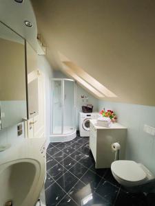 ein Badezimmer mit einem Waschbecken, einem WC und einer Mikrowelle in der Unterkunft Ferienwohnung Carlotta in der Villa Seeblick in Bad Saarow