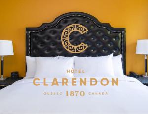a bed with a hotel clermont sign on it at Hotel Clarendon in Quebec City
