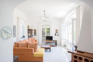 ein Wohnzimmer mit Sofa und Fernseher in der Unterkunft Appartamento immerso nel verde in Capri