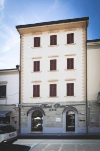 a large white building with windows on a street at Hotel Posta in Cecina