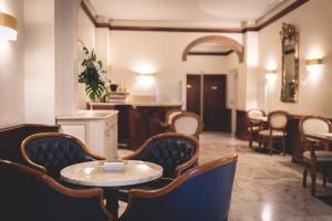 a room with chairs and a table and a table at Hotel Posta in Cecina