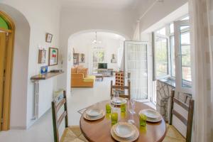 ein Esszimmer und ein Wohnzimmer mit einem Holztisch in der Unterkunft Appartamento immerso nel verde in Capri