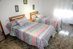 two beds in a hotel room with two beds at AMPLIO APTO en ROQUETAS in Roquetas de Mar