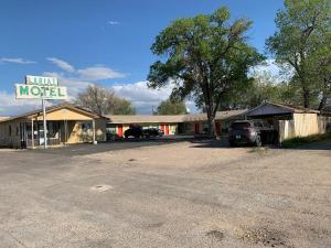 a motel with a car parked in a parking lot at Lariat Motel in Moriarty