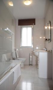 bagno bianco con lavandino, vasca e servizi igienici di Pico da Costa a Barreiros