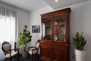 President Suite في ساليرنو: خزانة خشبية في غرفة مع كرسيين