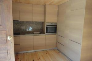 a kitchen with wooden cabinets and a stove at Casa do Palheiro in Miranda do Douro