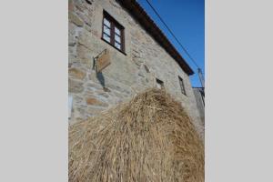 a stack of hay on the side of a building at Casa do Palheiro in Miranda do Douro
