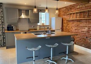 a kitchen with a counter and two bar stools at Rowley Farm Holidays in Worcester