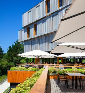 un restaurante con mesas y sombrillas frente a un edificio en Numad Studios, en San Sebastián