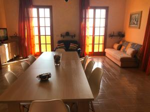 una sala de estar con una gran mesa de madera y sillas en Dimora del Sole, en Porto Cesareo