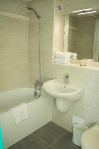 a bathroom with a sink and a tub and a toilet at Hotel les Tourrades in Cannes