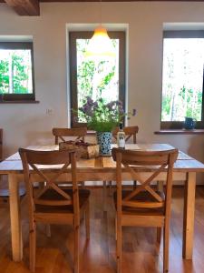 uma sala de jantar com uma mesa de madeira e cadeiras em Villa & Jacuzzi nad rzeka Wkra em Goławice