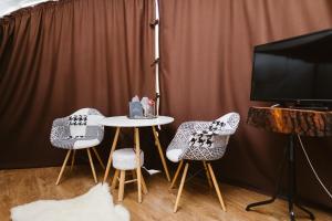 a table and chairs in a room with a tv at Wegloo in Azuga