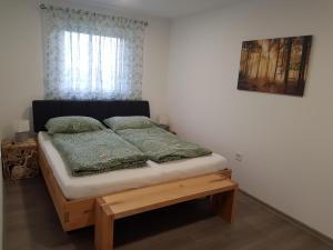 a bedroom with a bed with a wooden platform at Ferienwohnung Weizblick in Weiz