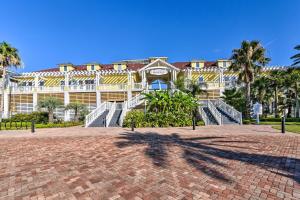 a large building with palm trees in front of it at Gulf View and Beach Access Galveston Resort Condo! in Galveston