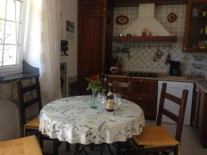 una cocina con una mesa con botellas de vino y copas en Appartamento immerso nel verde, en Capri