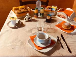 un tavolo con una tazza di caffè e un piatto di cibo di B&B Linu Ruiu a Santu Lussurgiu
