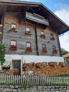 a wooden house with red flowers in the windows at Ferienhaus Grofn in Matrei in Osttirol