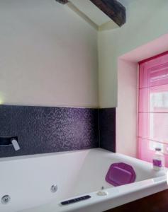 ein Badezimmer mit einem lila Waschbecken und einem Fenster in der Unterkunft Loft "Elegante" Lila in Ubrique