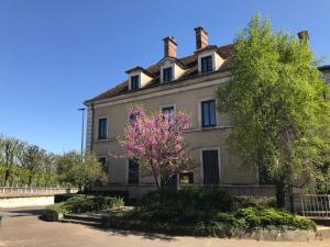 ein Haus mit einem rosa Baum davor in der Unterkunft Studio plein coeur d'Auxerre in Auxerre