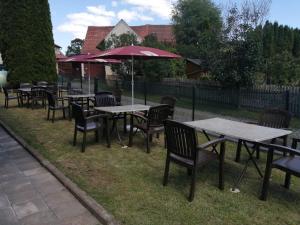 a group of tables and chairs with an umbrella at Pension Restaurant Ewald in Bischofsheim an der Rhön