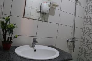 a bathroom with a white sink and a mirror at Cozy Studio Apartment In Bahria town in Rawalpindi