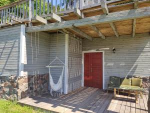 a porch with a red door and a wooden deck at Srokowski Dwór 1 - Stara Kuźnia - Prywatna Sauna ! in Srokowo