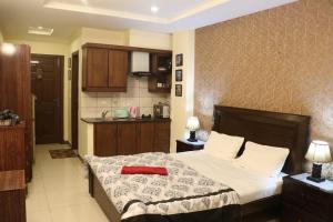 a bedroom with a bed with a red towel on it at Cozy Studio Apartment In Bahria town in Rawalpindi