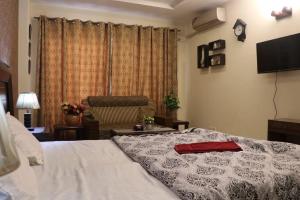 a bedroom with a bed and a chair at Cozy Studio Apartment In Bahria town in Rawalpindi