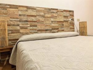 a bedroom with a bed and a brick wall at Villetta Siciliana "Dal PICCIOTTO" in Marsala