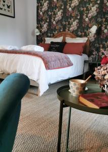 een slaapkamer met een bed en een salontafel bij Quatre Chats sous un Pin in Le Thoureil