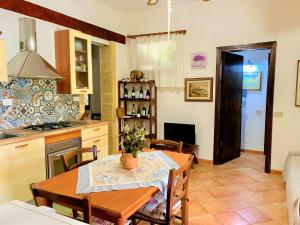 a kitchen and dining room with a table and chairs at Villetta Siciliana "Dal PICCIOTTO" in Marsala