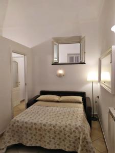 een slaapkamer met een bed en een spiegel bij NIDO AMICO in Loano