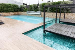 a swimming pool with a deck and a bench in it at Viña Retreat - 2BR W / Pool, Wifi & Parking in Viña del Mar