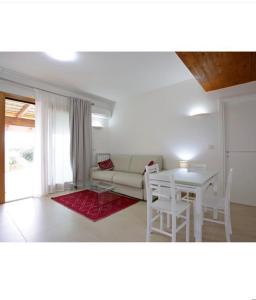een woonkamer met een bank en een tafel bij Cala Azul Residence B&B in Alghero