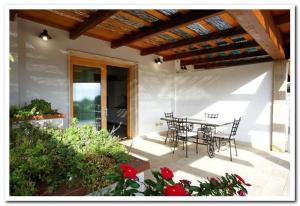 een patio met een tafel en stoelen op een huis bij Cala Azul Residence B&B in Alghero