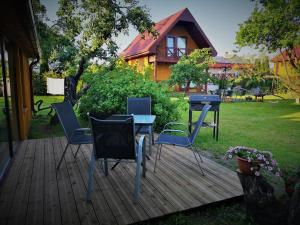 a deck with chairs and a table and a grill at Namiņš AMRAI in Ventspils