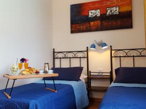 a room with two beds and a table with fruit on it at Poggiofelice B&B in Zafferana Etnea