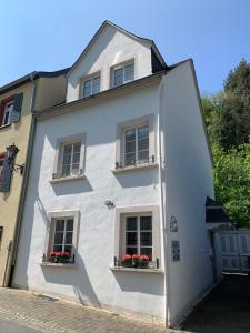 un bâtiment blanc avec deux fenêtres et des boîtes de fleurs dans l'établissement Casa Elisa - Das Ferienhaus zum Wohlfühlen, à Bernkastel-Kues