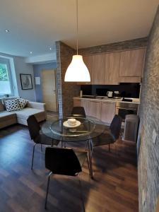 a dining room and kitchen with a glass table and chairs at Apartments Volče in Tolmin